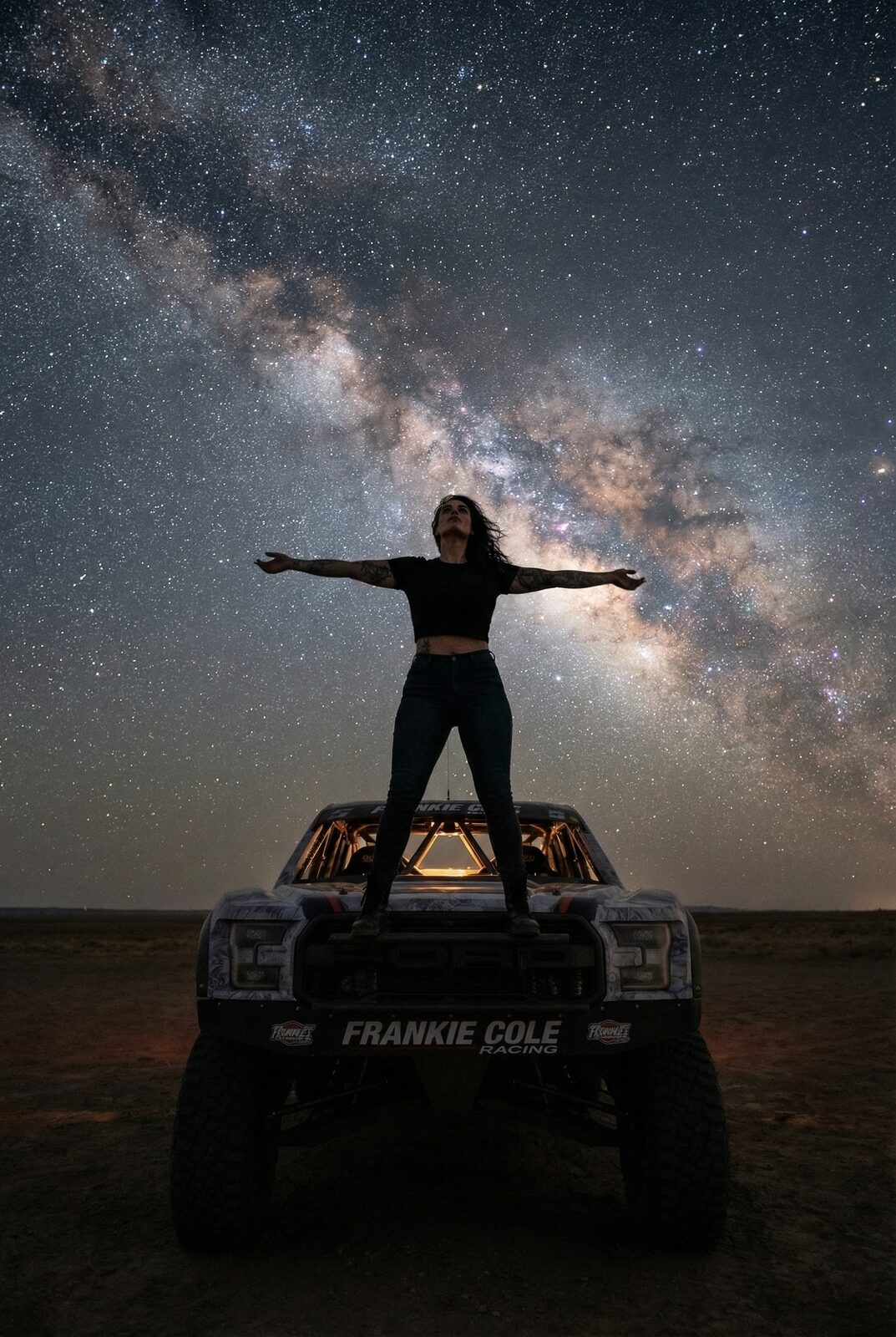 She sleeps with it open to hear the yard at night — wind through the carcasses, metal ticking as it cools, the small animals moving. Out here under the whole Milky Way, that sound is what home is. She isn’t running from anything. She is exactly where she wants to be.